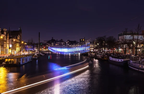 Cruise boat with blur light moving on night canals of Amsterdam.