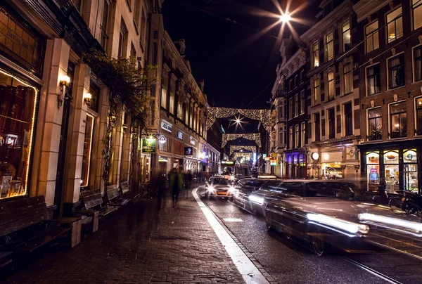 Headlights car passing down street in night Amsterdam.