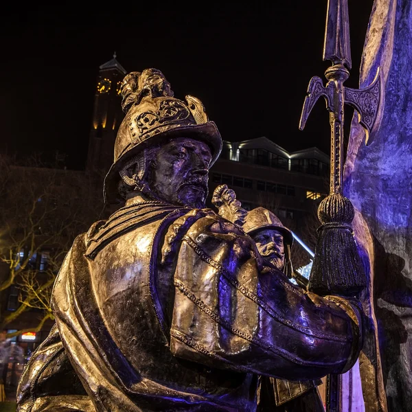 AMSTERDAM, NETHERLANDS - DECEMBER 19, 2015: Bronze figures of soldiers on central square of city lit with street light at night on December 19, 2015 in Amsterdam - Netherland.