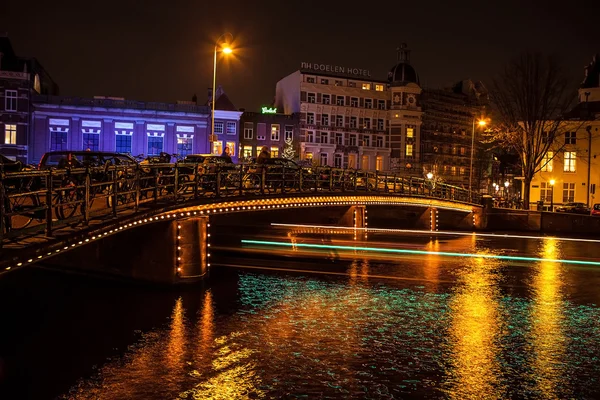 Cruise boat with blur light moving on night canals of Amsterdam.