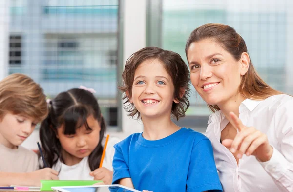 Beautiful teacher with mixed race classroom