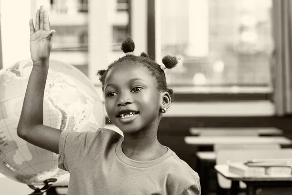 African girl at school with earth globe in background, geography