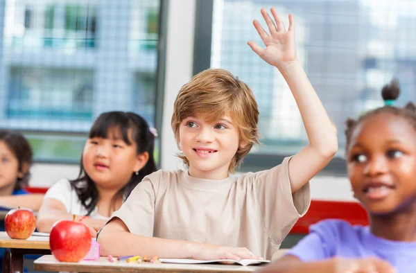 Pupil raising hand in classroom