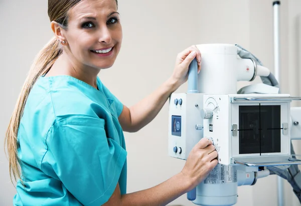 Beautiful female doctor setting up x-ray machine