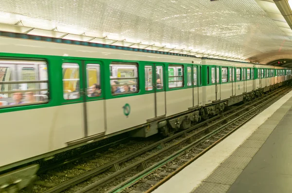 Metro train speeds up in subway station.
