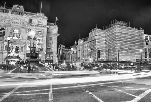 LONDON - SEPTEMBER 27 : Motion blurred traffic and people pass t