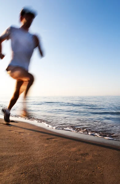 Young man running on a beach at sunrise. Motion blur effect. Concepts: well-being, vitality, healthy life, vacation, sport, training