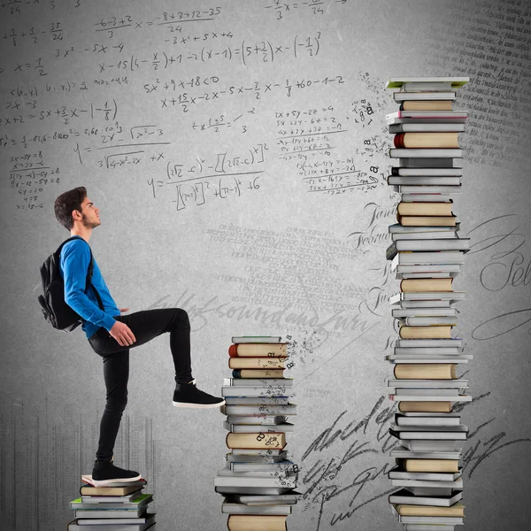 Boy with backpack climbs a books scale