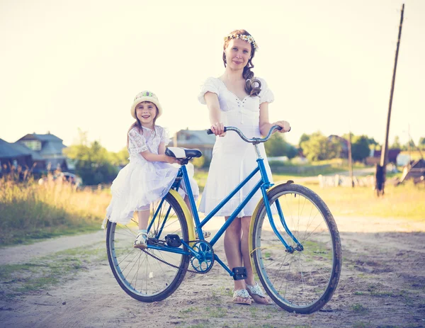 Beautiful mother and daughter traveling on a bicycle.
