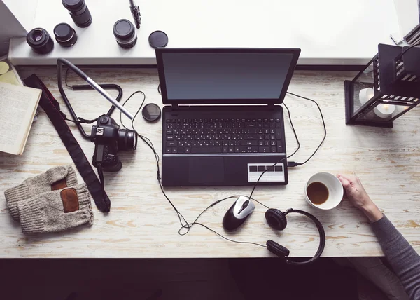 Workplace with open laptop with black screen  on modern wooden desk, angled notebook on table in home interior, filtered image