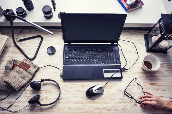 Workplace with open laptop with black screen  on modern wooden desk, angled notebook on table in home interior, filtered image