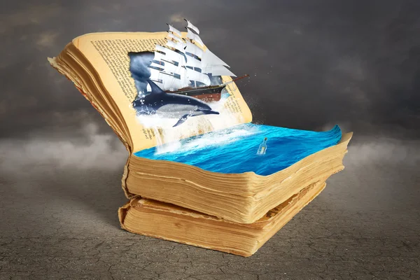 Concept of reading. Opened magic book with torn page.Dolphin and