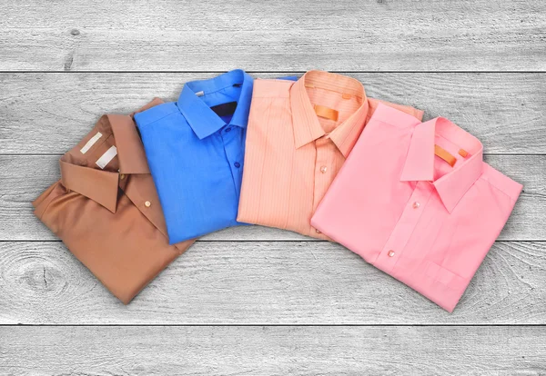 Colored shirts on white wooden plank