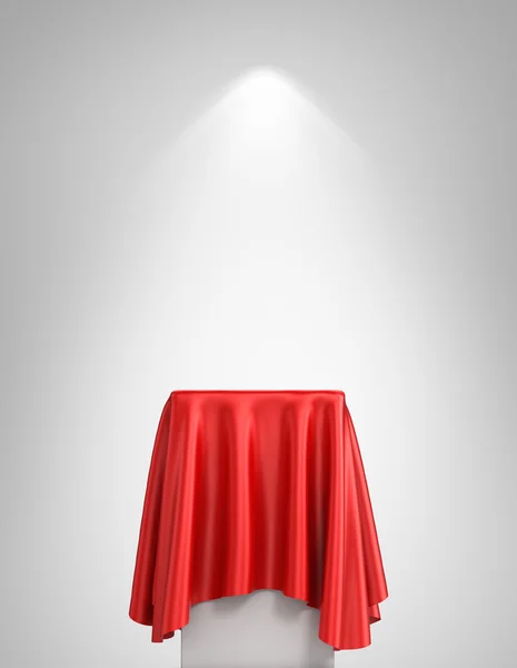 Presentation pedestal covered with a red silk cloth in front of