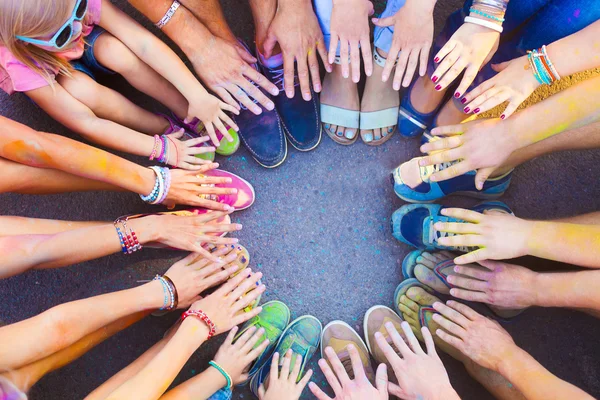 Friends putting their feet and hands together in a sign of unity