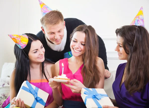 Joyful girl at birthday party surrounded by friends at party
