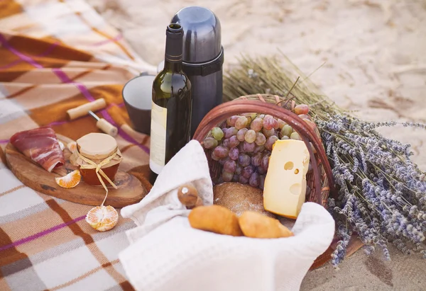 Autumn picnic by the sea with wine, grapes, bread and cheese