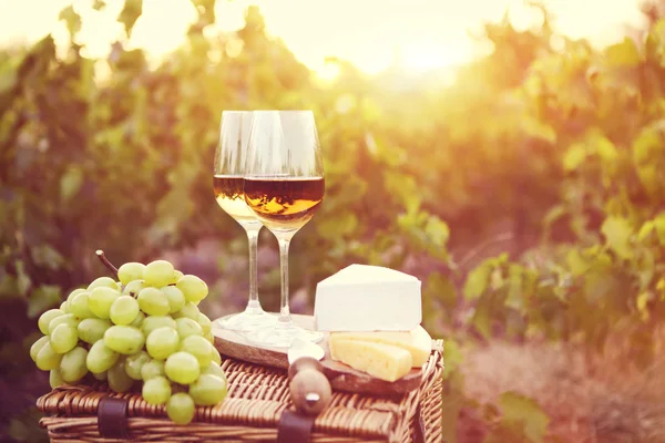 Various sorts of cheese and two glasses of white wine