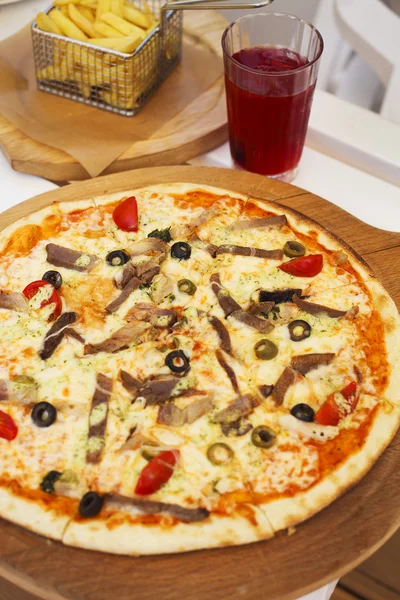 Hot pizza with meat, tomatoes and olives