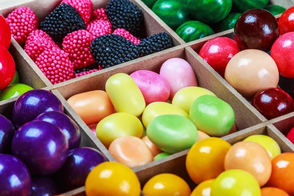 Multi colored candy and chewing gum in a wooden box