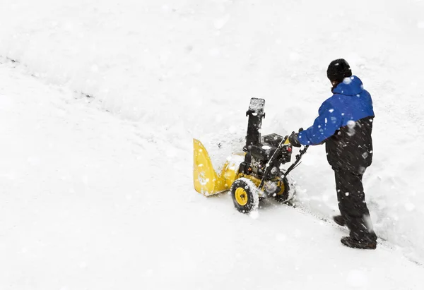 Man with snow blowing machine