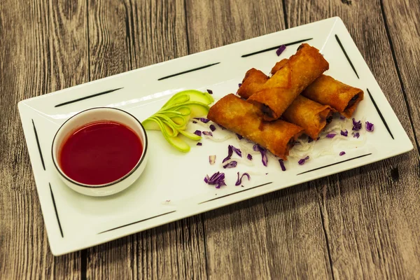 Appetizing Chinese fried pancakes with vegetables with sweet-sour sauce.