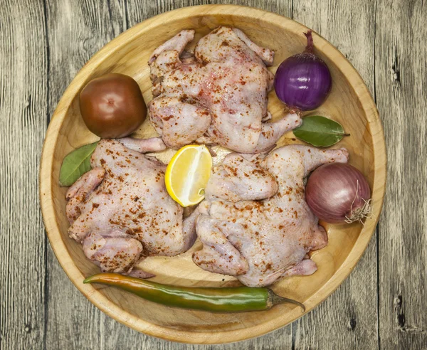 Three fresh raw chicken on a wooden tray with lemon and chilli  on the wooden background