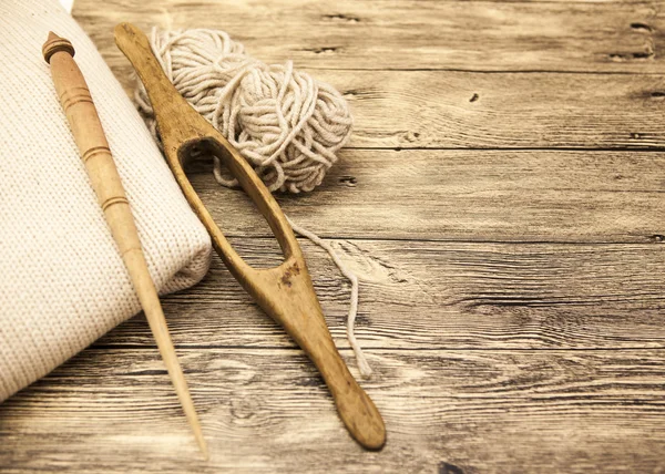 Excellent mocap two old wooden spindle with a ball of wool thread for the manufacture of woolen threads on a wooden background