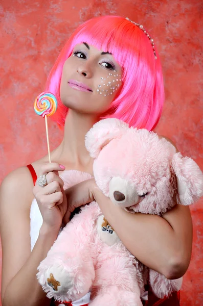 Girl with pink hair holding lollipop