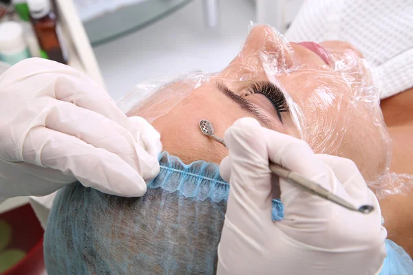 Professional cleansing of acne in a beauty salon.