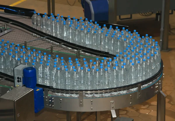 Plastic water bottles on conveyor and water bottling machine ind
