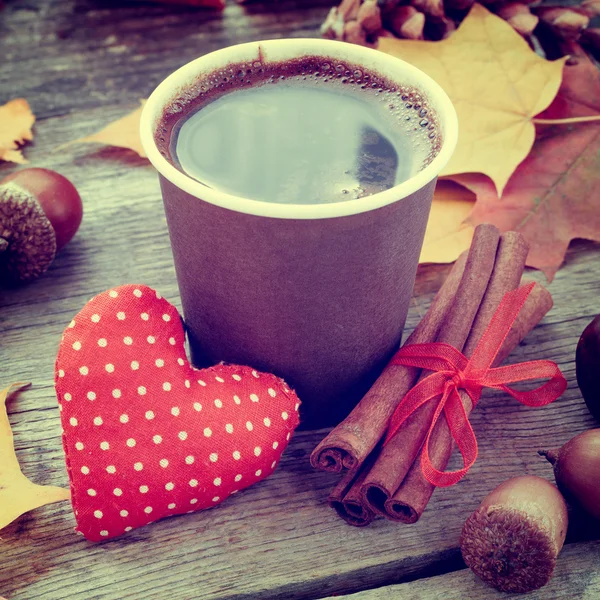 Coffee cup, red heart and autumn still life on old table
