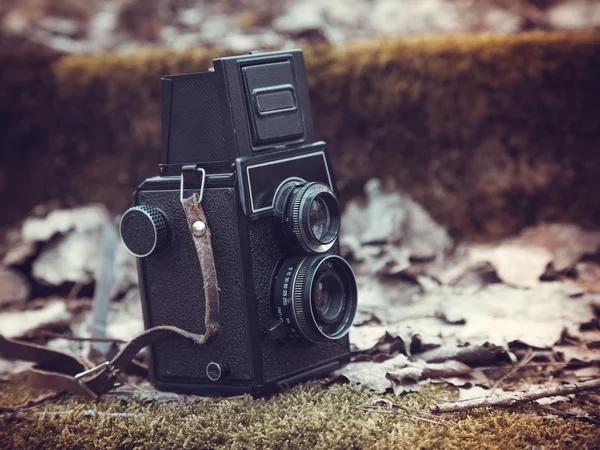 Vintage stylized photo of retro film camera on old stairs covere