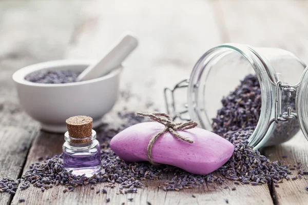 Bars of homemade soaps, dry lavender flowers and essential oil.