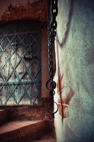 Fragment of medieval dungeon prison. Focus on ancient door.