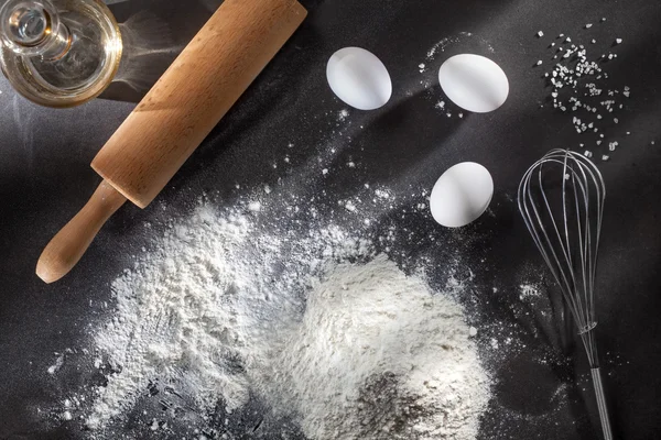 Flour and ingredients on black table