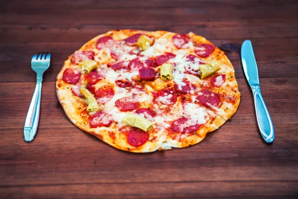 Tasty fresh pizza with fork and knife