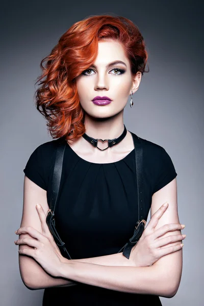Beautiful woman with red hair in a black dress