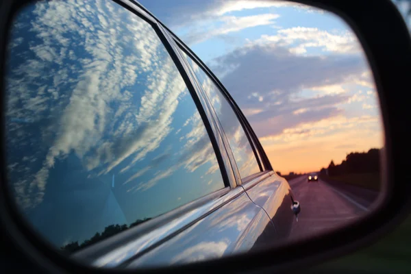 Blue landscape sunset reflect in mirror of car. Selective focus.