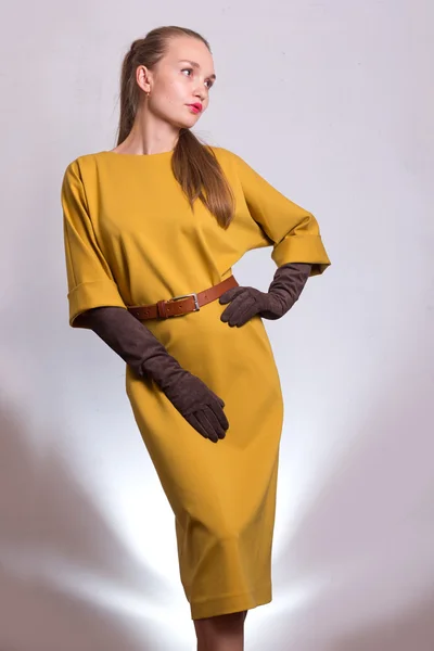 Beautiful sexy young business woman brown hair with natural skin wearing yellow dress business clothes for meetings walks autumn fall collection perfect body shape party style.