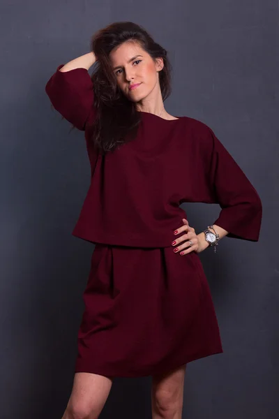 Beautiful sexy young business woman brown hair with natural skin wearing wine-coloured dress suit top skirt business clothes for meetings walks autumn fall collection perfect body shape party style.