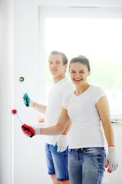 Boy and girl painting the walls in the apartment