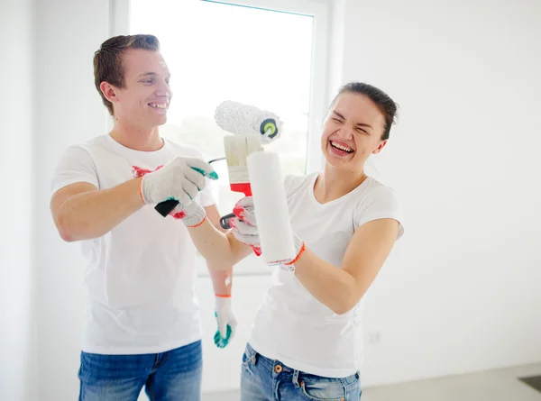 Young man and woman have fun during repair in the house.