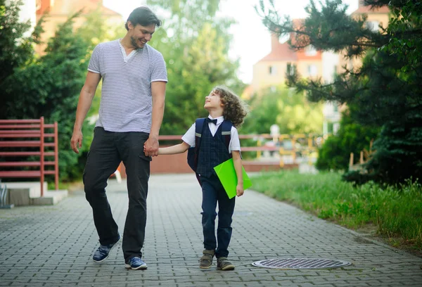 Dad\'s taking a first grader to school.