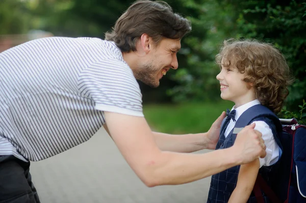 Father with his son-first-graders in the school yard.