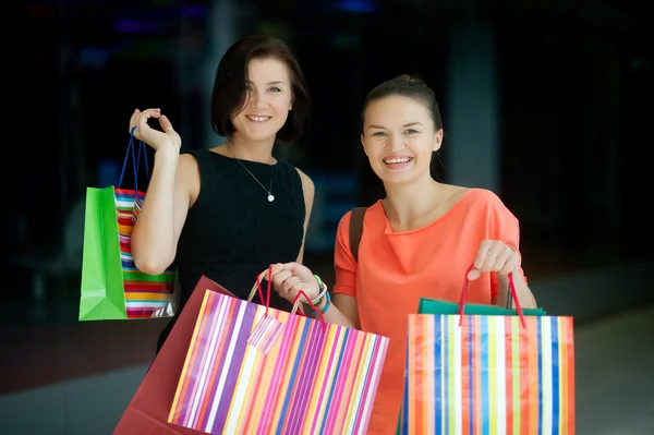 Two cute young women do shopping at the mall.
