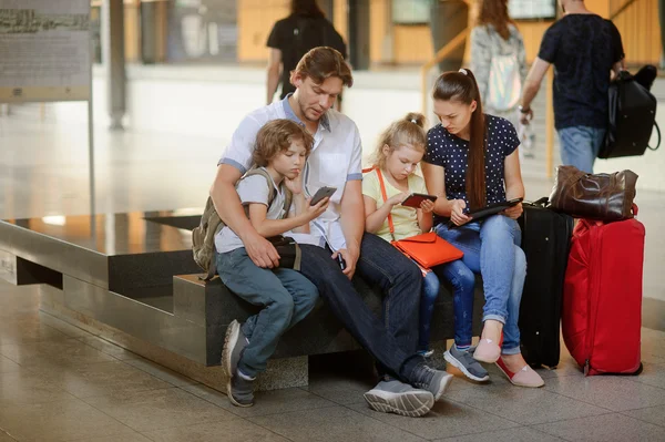 Young parents with two children at the railway station.