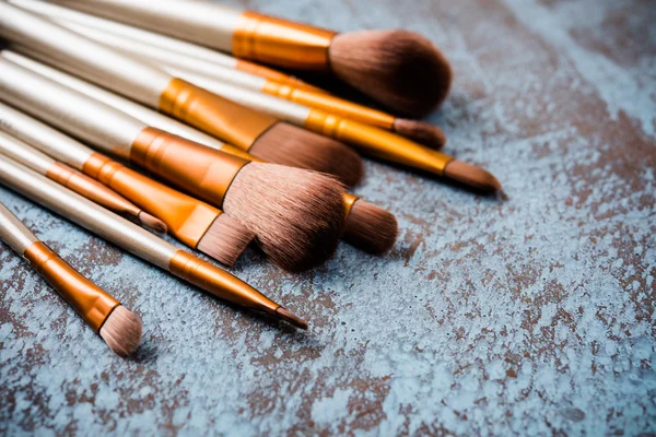 Makeup brushes collection, new make-up tools set on painted back