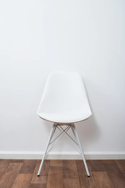 White stylish designer chair near the wall