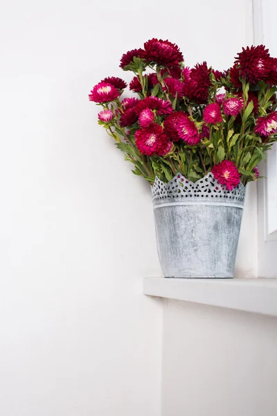 Red flowers in metal vase